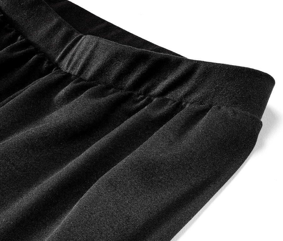 Egy fekete, női bőszárú sportnadrág részlete.