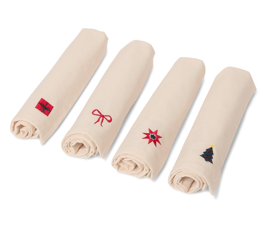 Négy feltekert bézs színű szalvéta karácsonyi motívumokkal.