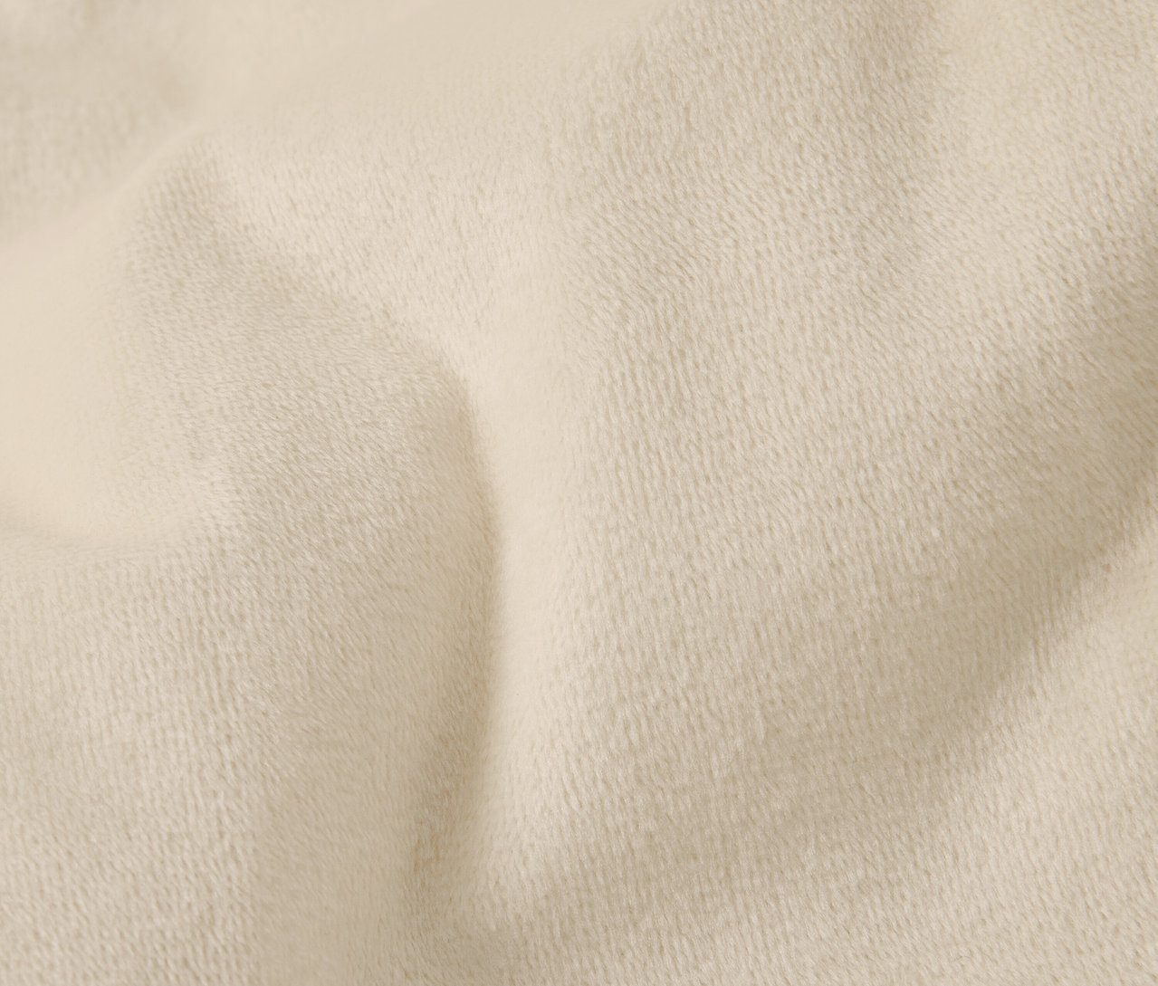 Krémszínű anyag közeli képe finom textúrával és ráncokkal.