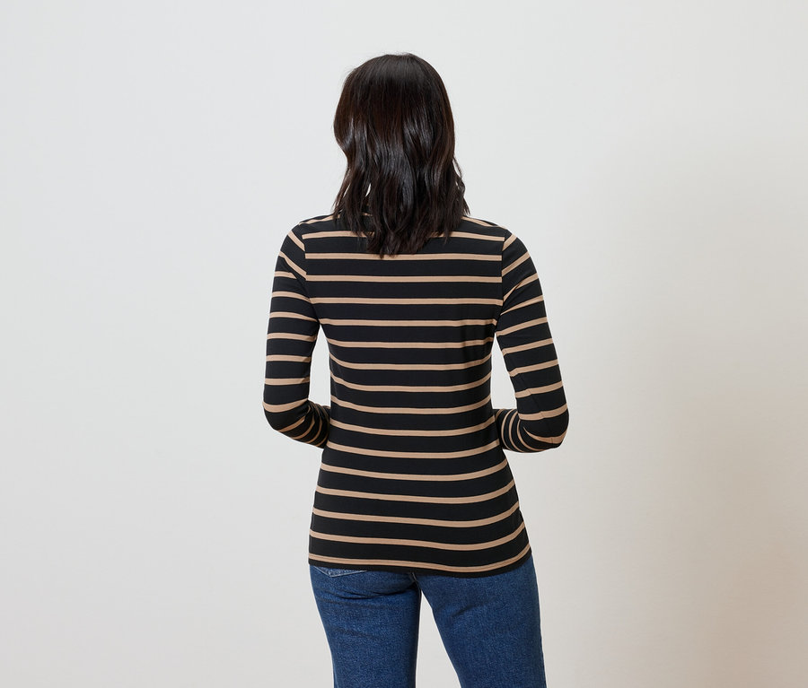 Hátulnézetből látható egy sötét hajú nő, aki csíkos hosszú ujjú felsőt és kék farmert visel.