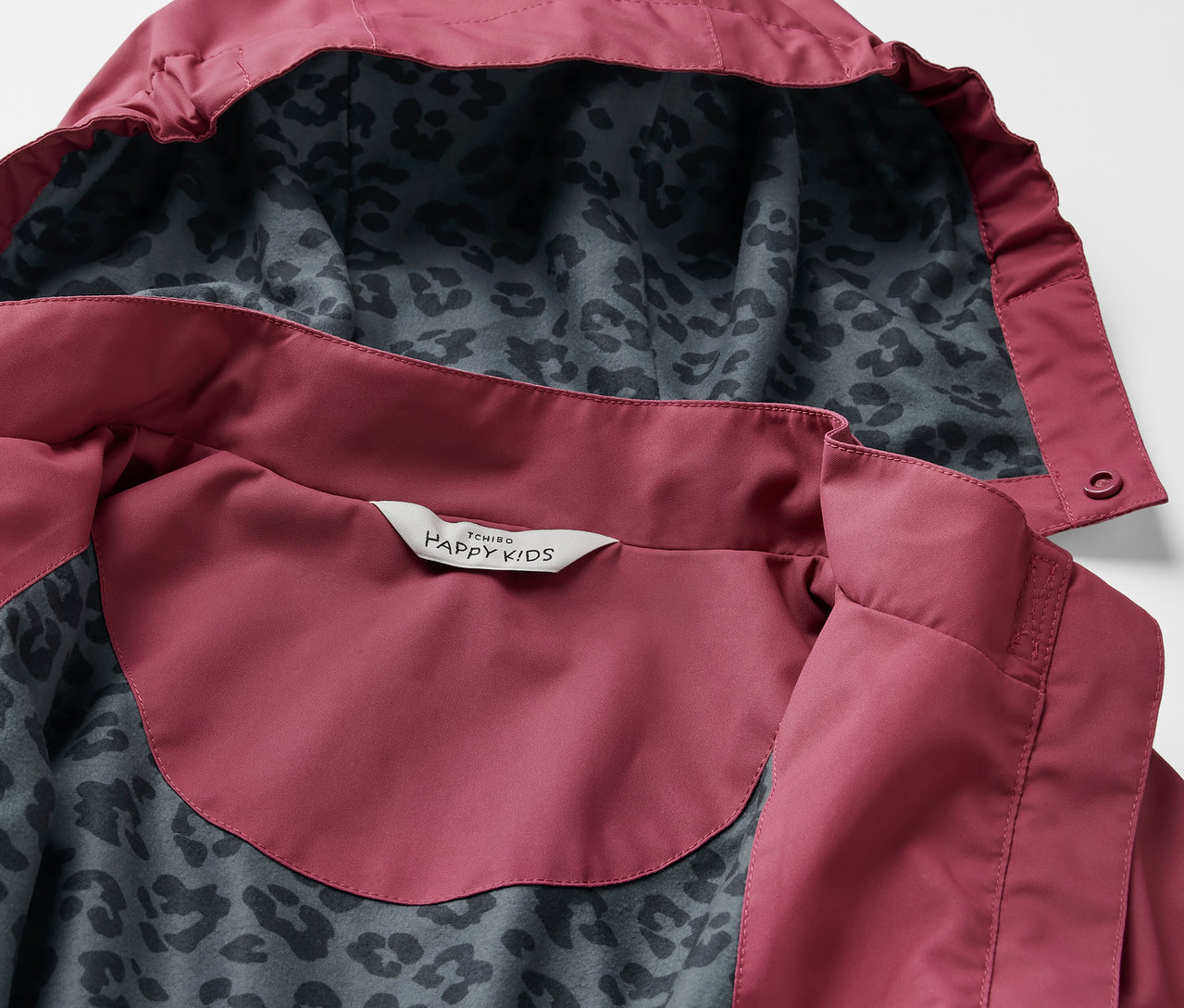 Egy gyermek esőparka részlete, kapucnival és leopárdmintával belül.