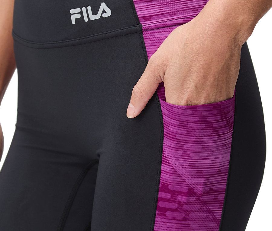Nő visel fekete leggingset rózsaszín mintával és Fila logóval.