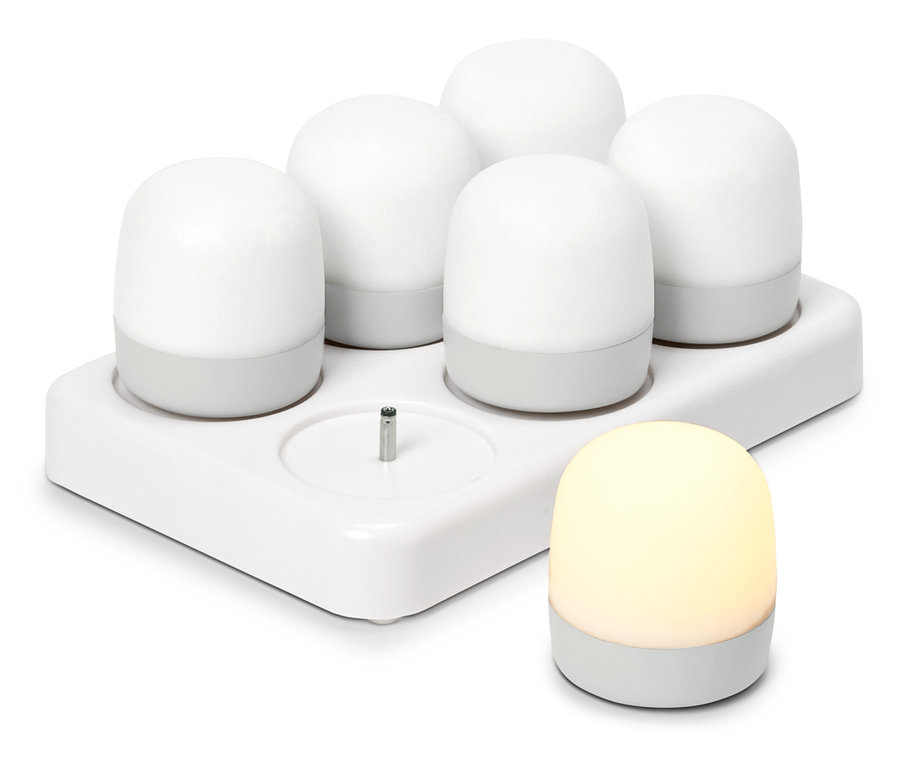 Öt fehér, kerek éjszakai fény egy töltőállomáson, mellette egy másik világító éjszakai fény áll.