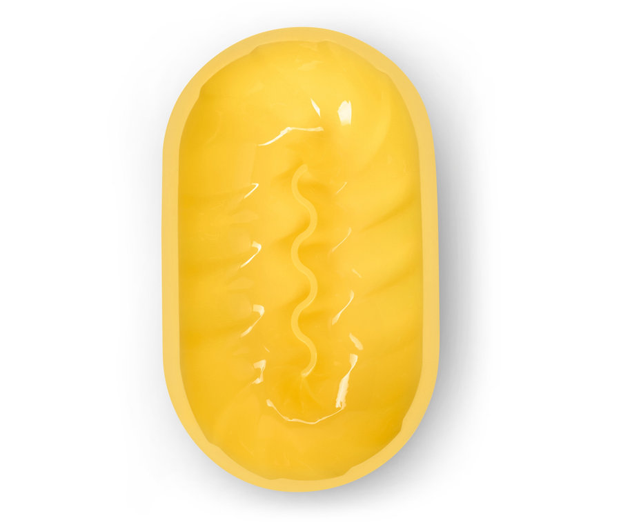 Felülnézet egy hosszúkás, sárga fürdőbombáról, középen hullámos barázdával, fehér háttérrel.