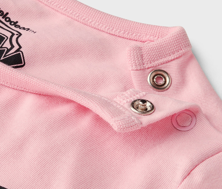 Közelkép a patentokról egy rózsaszín ruhadarabon.