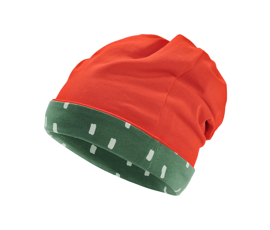 Egy kifordítható kisgyerek sapka részlete, kívül narancssárga, belül zöld, fehér pöttyökkel.