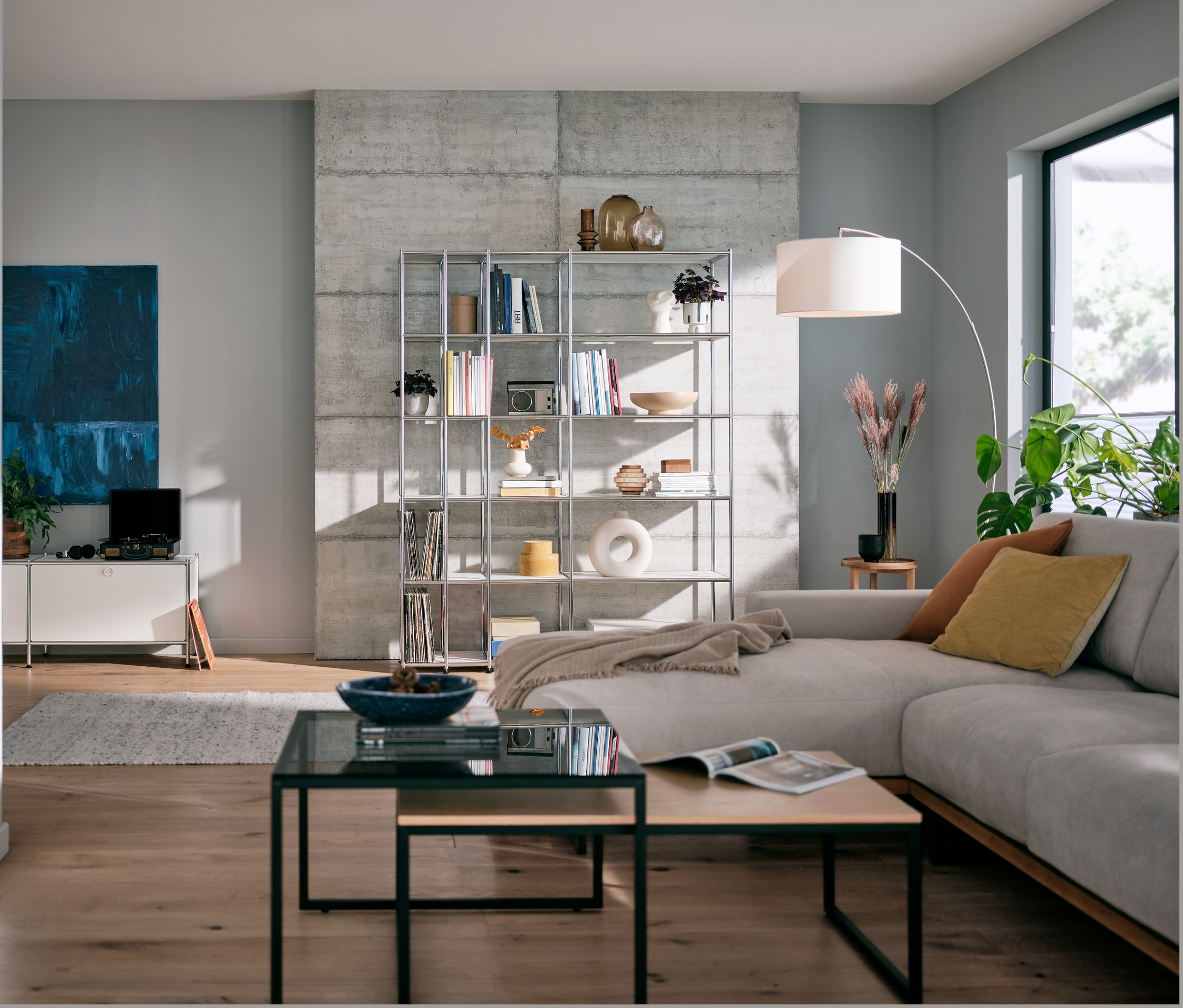 Nappali fehér fém polccal, textil állólámpával és 2 dohányzóasztal szettel.