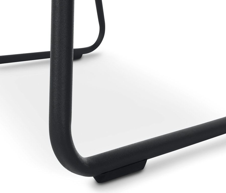 A bézs színű, kárpitozott kagylószék fémlábainak részlete.