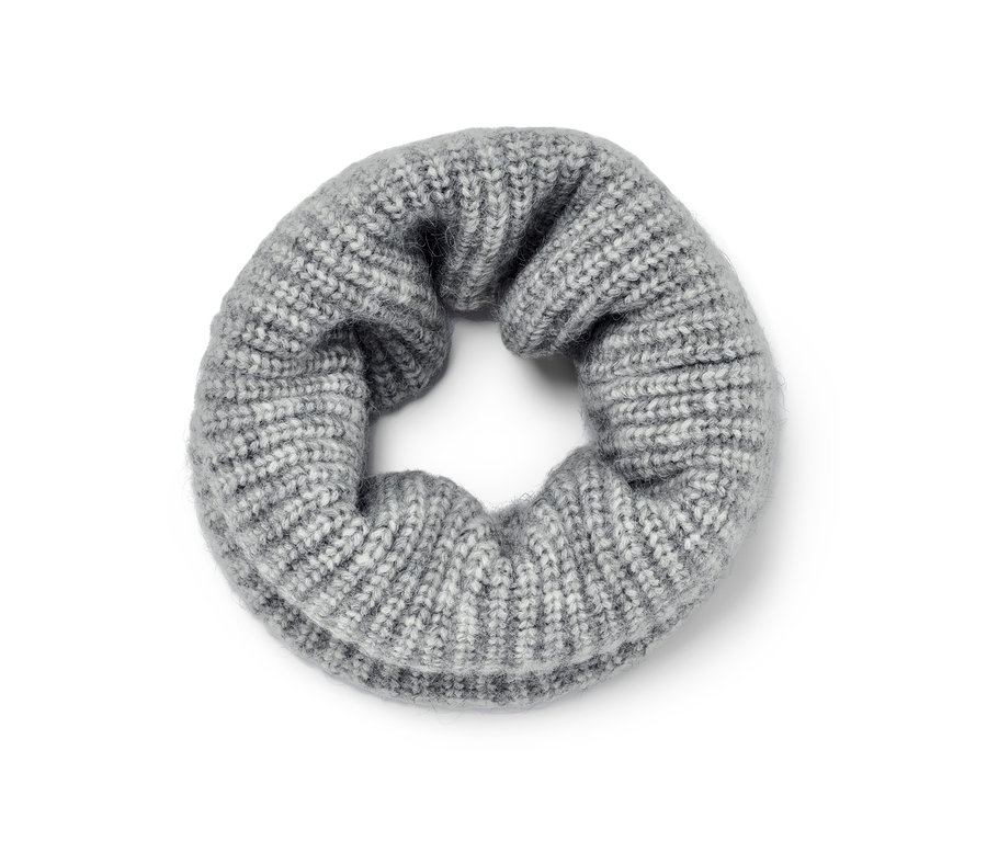 Egy szürke női kötött csősál fekszik a földön.