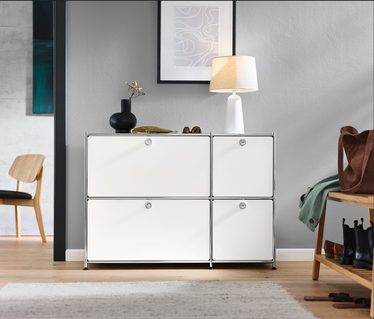 Előszoba fehér »CN3« komóddal, 4 lenyitható ajtóval, lounge székkel, ülőpad cipőtartóval és fehér textilernyős asztali lámpával.