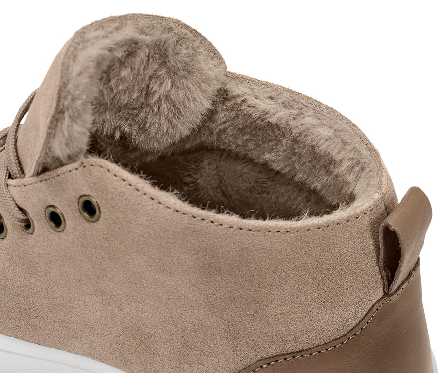 Egy plüssbéléssel ellátott női velúrbőr sneaker cipő részletfotója.