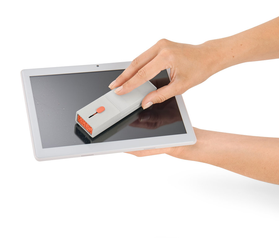 Nő tisztítja a tablet képernyőjét egy 4 az 1-ben elektronikai eszköz tisztítóval.