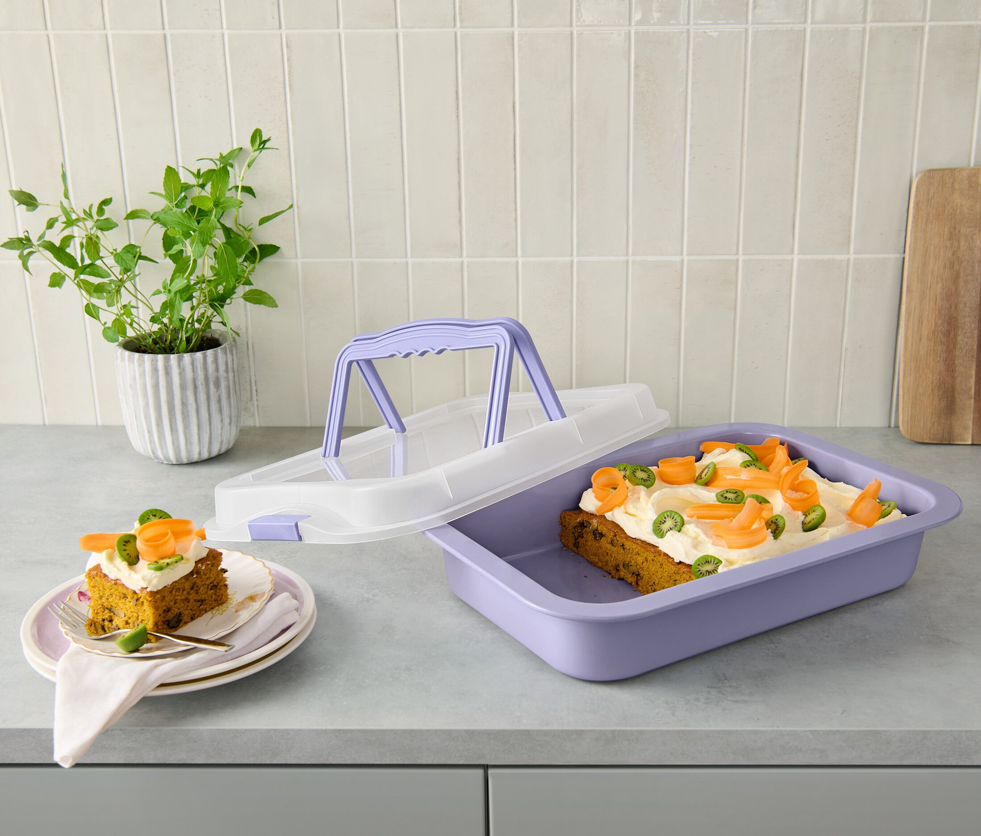 Két szelet sütemény tányéron és egy fedeles sütőforma süteménnyel a pulton.