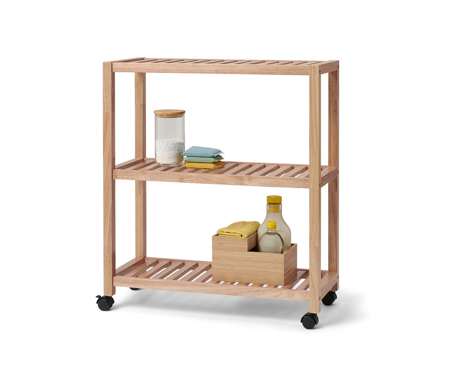 Háromszintes, görgős, tömörfa polc. A felső polcon egy üvegtartály és textíliák találhatók.