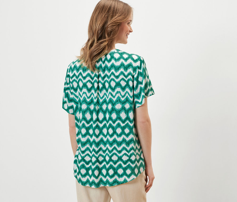 Nő visel egy mintás tunikablúzt.