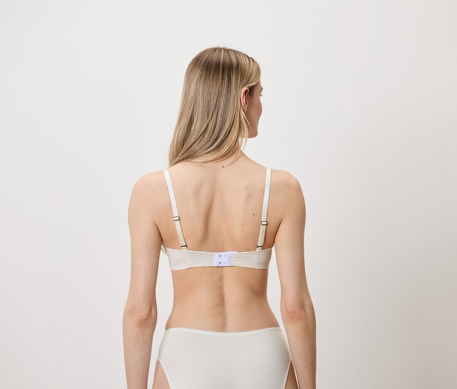 Hátulról látható egy szőke nő fehér melltartót és bugyit viselve.