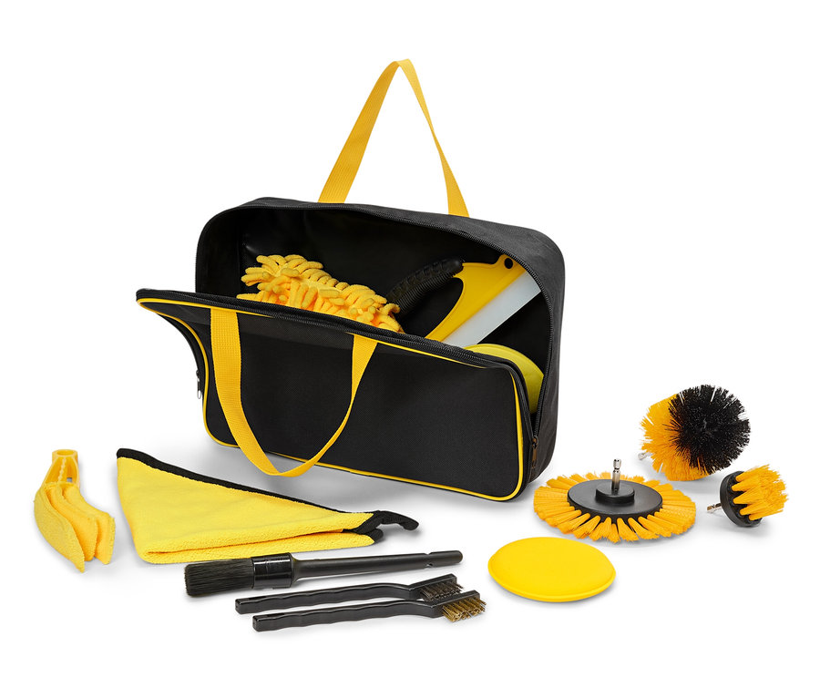 Egy fekete táska sárga fogantyúkkal tisztító eszközök készletét tartalmazza és veszi körül.