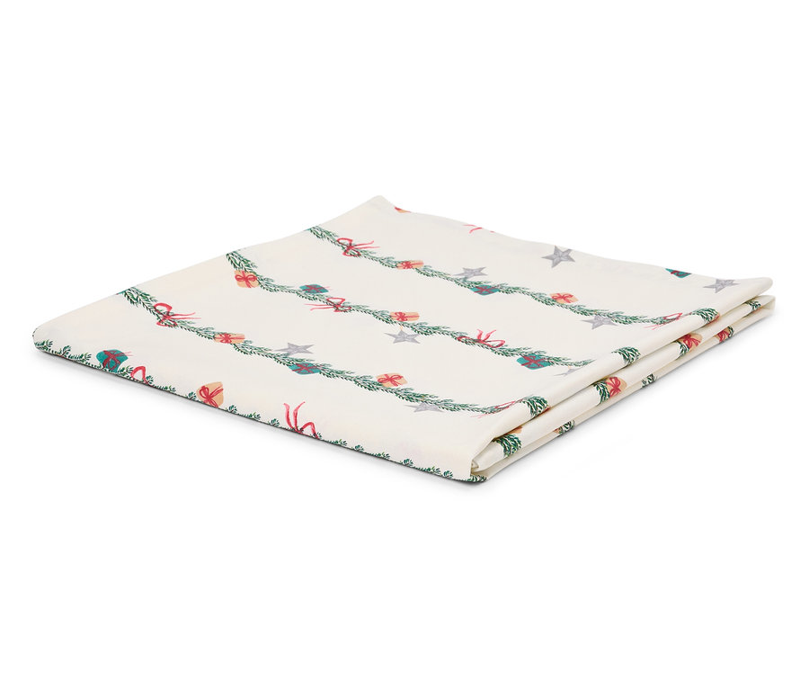 Összehajtott fehér asztalterítő karácsonyi motívummal, ágakkal, ajándékokkal és csillagokkal.