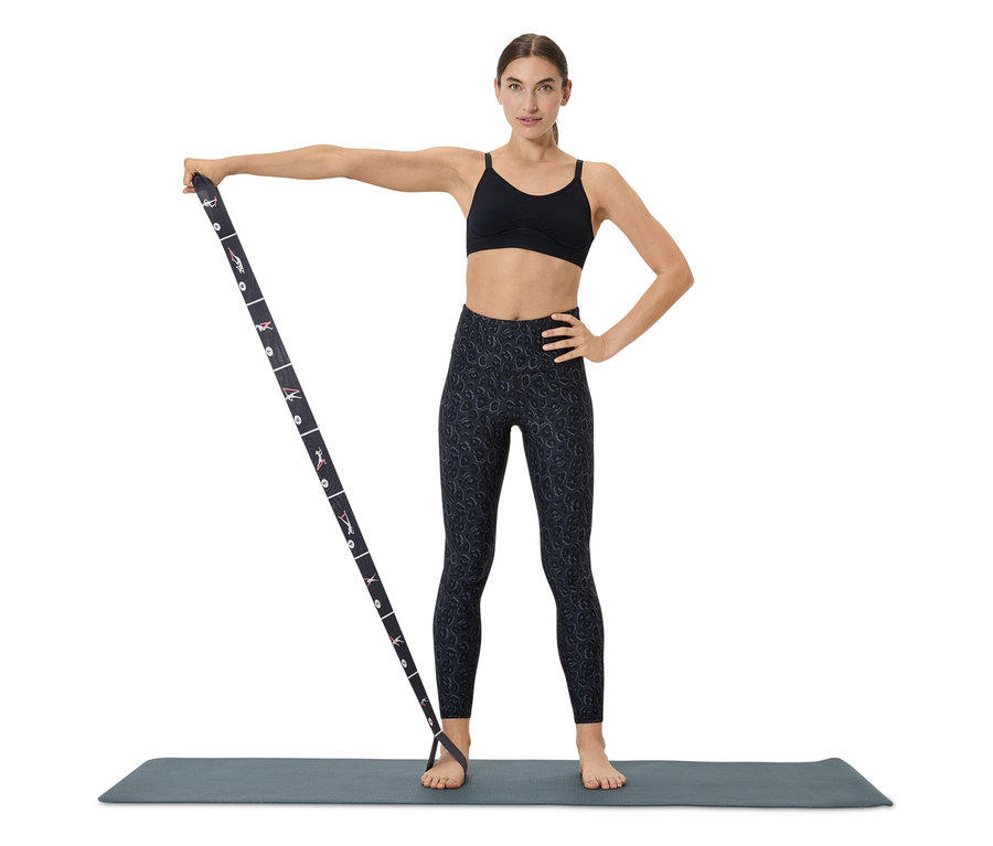 Nő edz egy szalaggal a matracon.