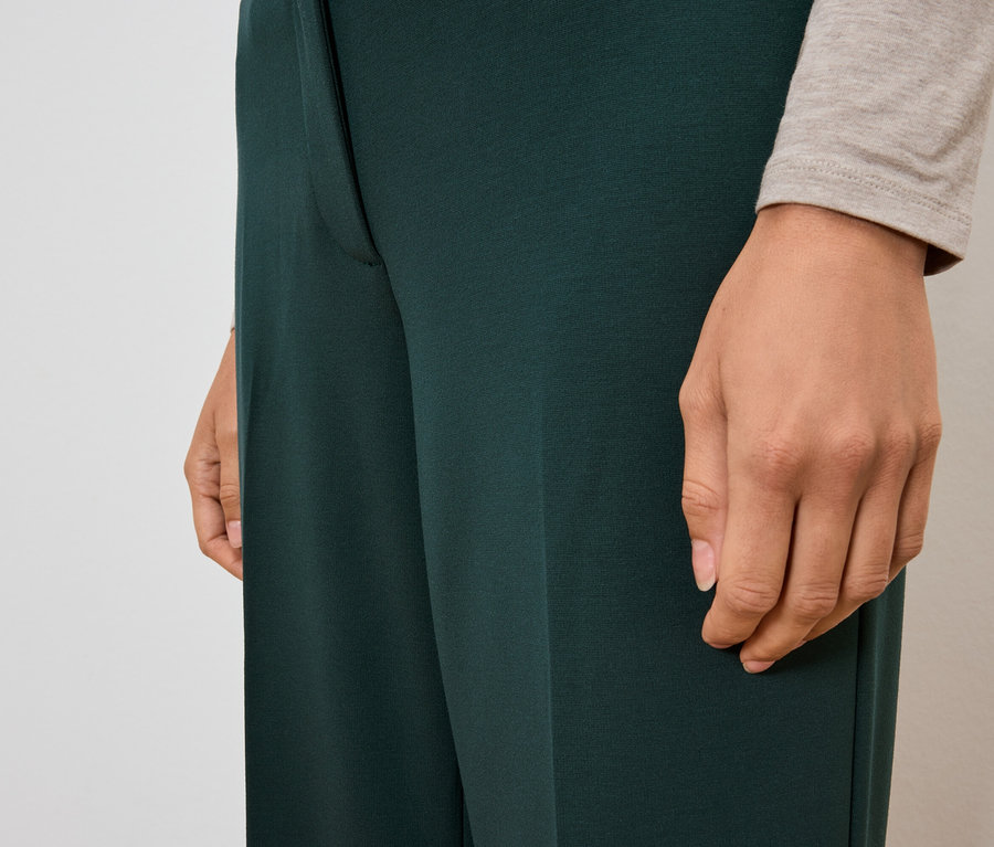 Egy nő visel egy sötétzöld nadrágot.