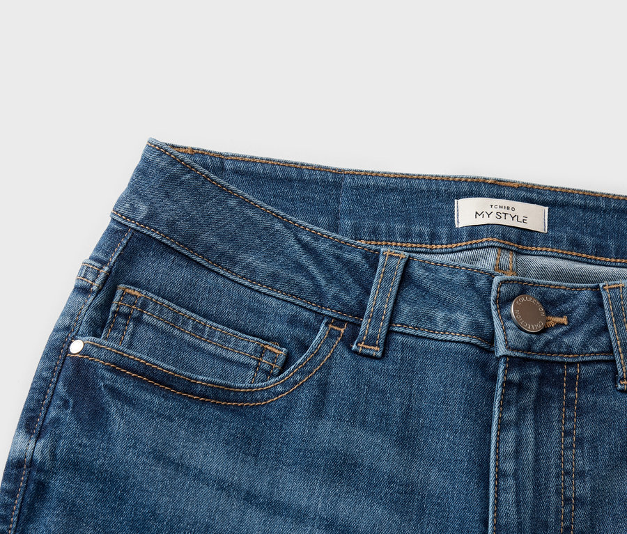 Farmeranyag közelképe zsebekkel és egy 'TCHIBO MY STYLE' címkével.