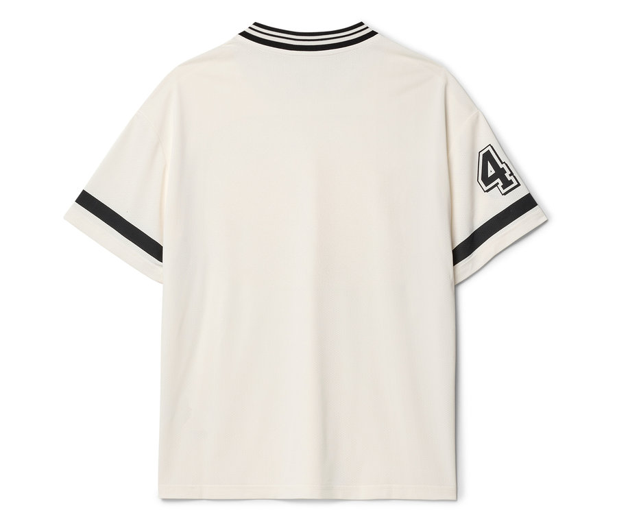 Hátulnézet egy krémszínű pólóról fekete csíkokkal a galléron és az ujjakon, valamint a 4-es számmal az ujjon.