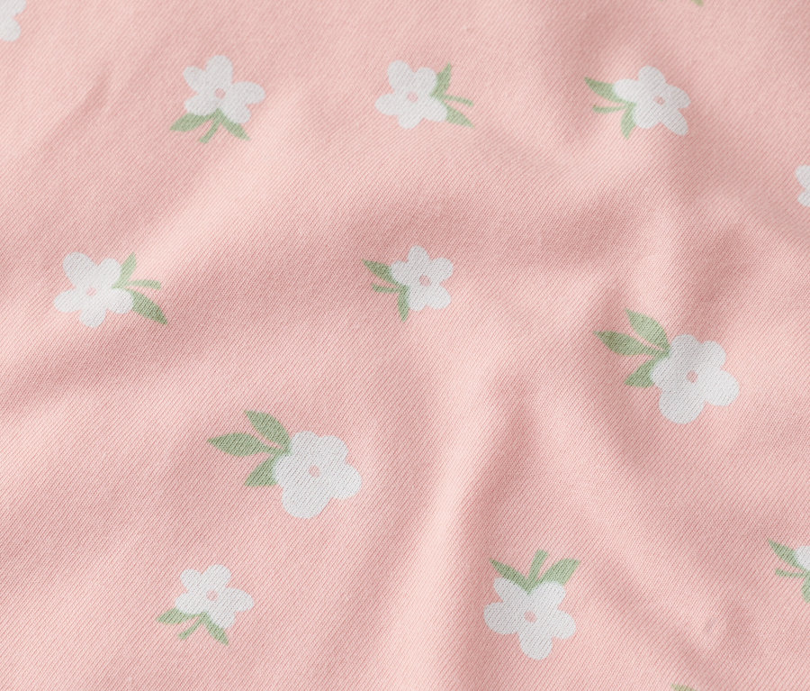 Rózsaszín szövet közeli képe fehér virágokkal.