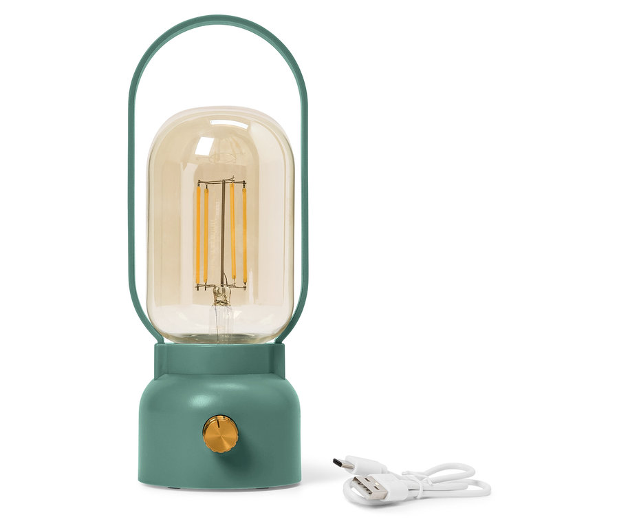 Egy zöld lámpa sárga üvegbúrával áll egy fehér USB-kábel mellett.