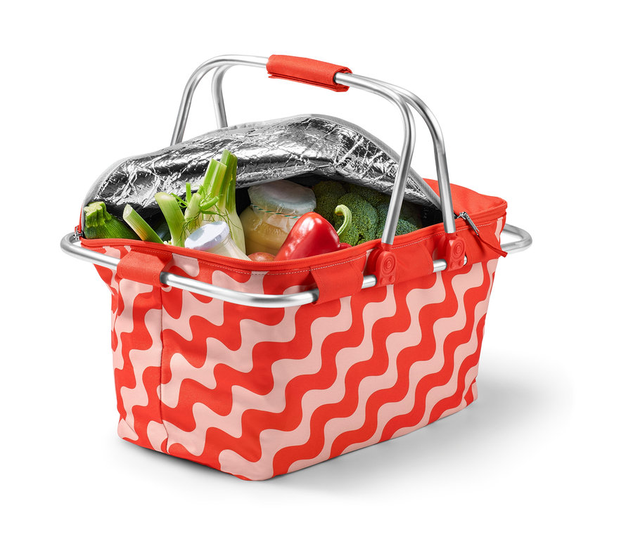 Egy nyitott, piros hullámos mintázatú, zöldségekkel teli, összecsukható hűtőkosár.