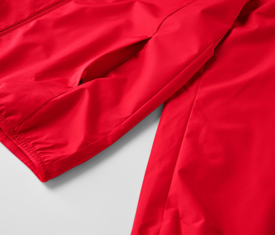 Egy piros férfi szélálló funkcionális dzseki részlete.