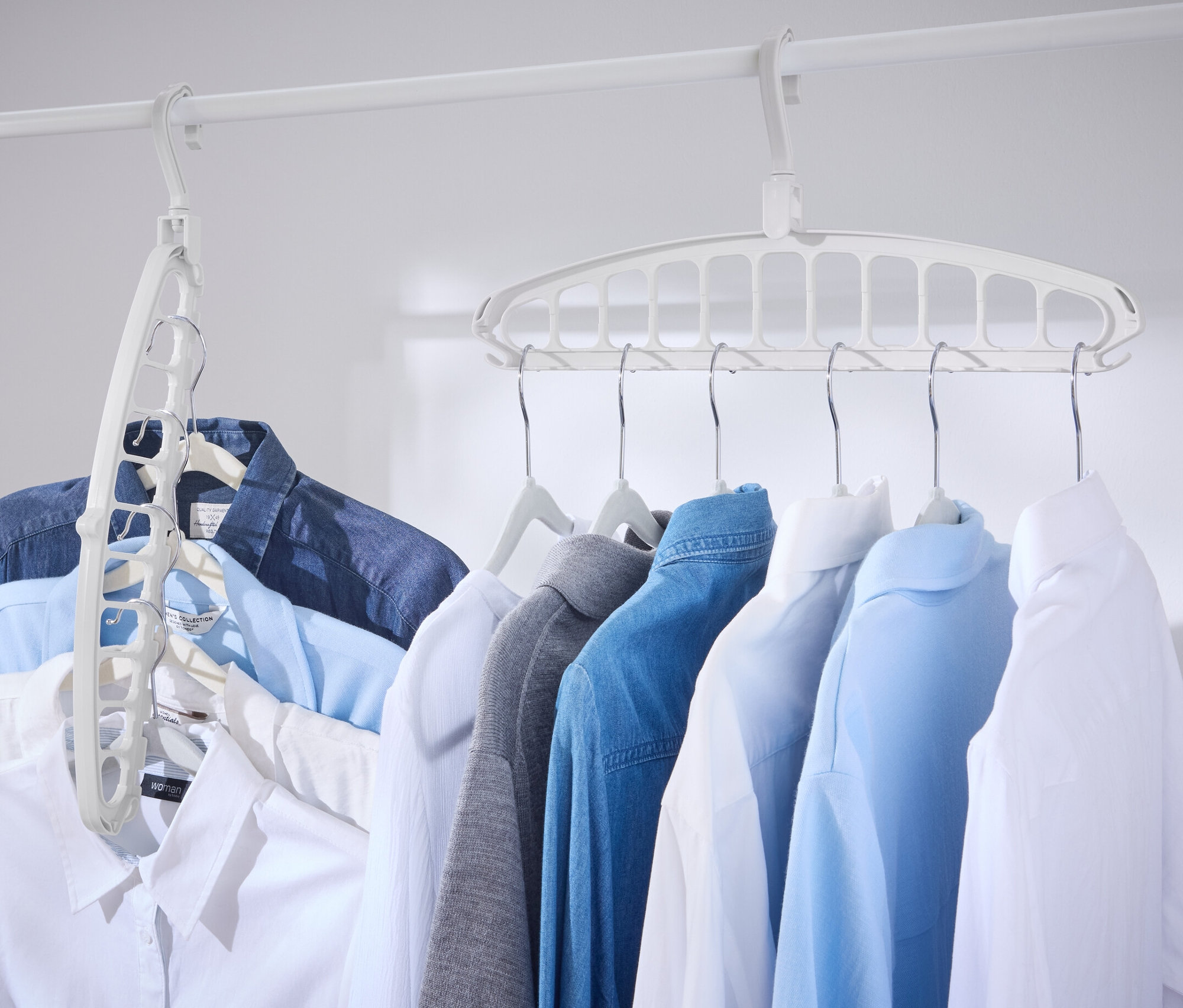Fehér rudakon több ing lóg, 2 multifunkciós vállfával.