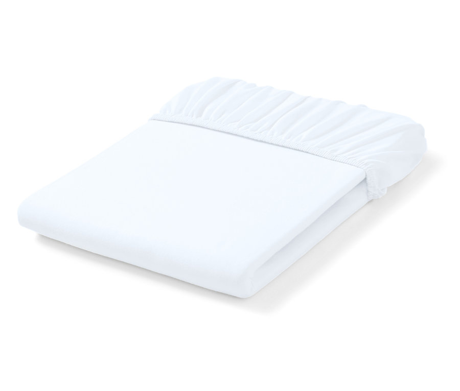 Összehajtott fehér, gumis lepedő.