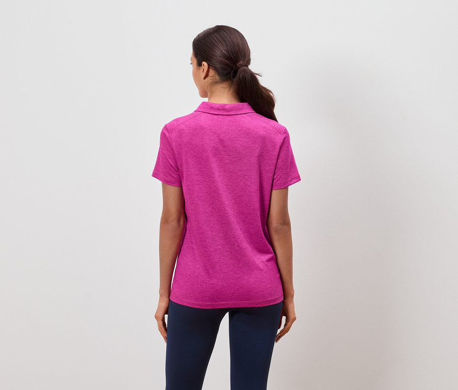 Hátulnézet egy lófarokba kötött hajú nőről, aki rózsaszín pólót és sötétkék nadrágot visel.