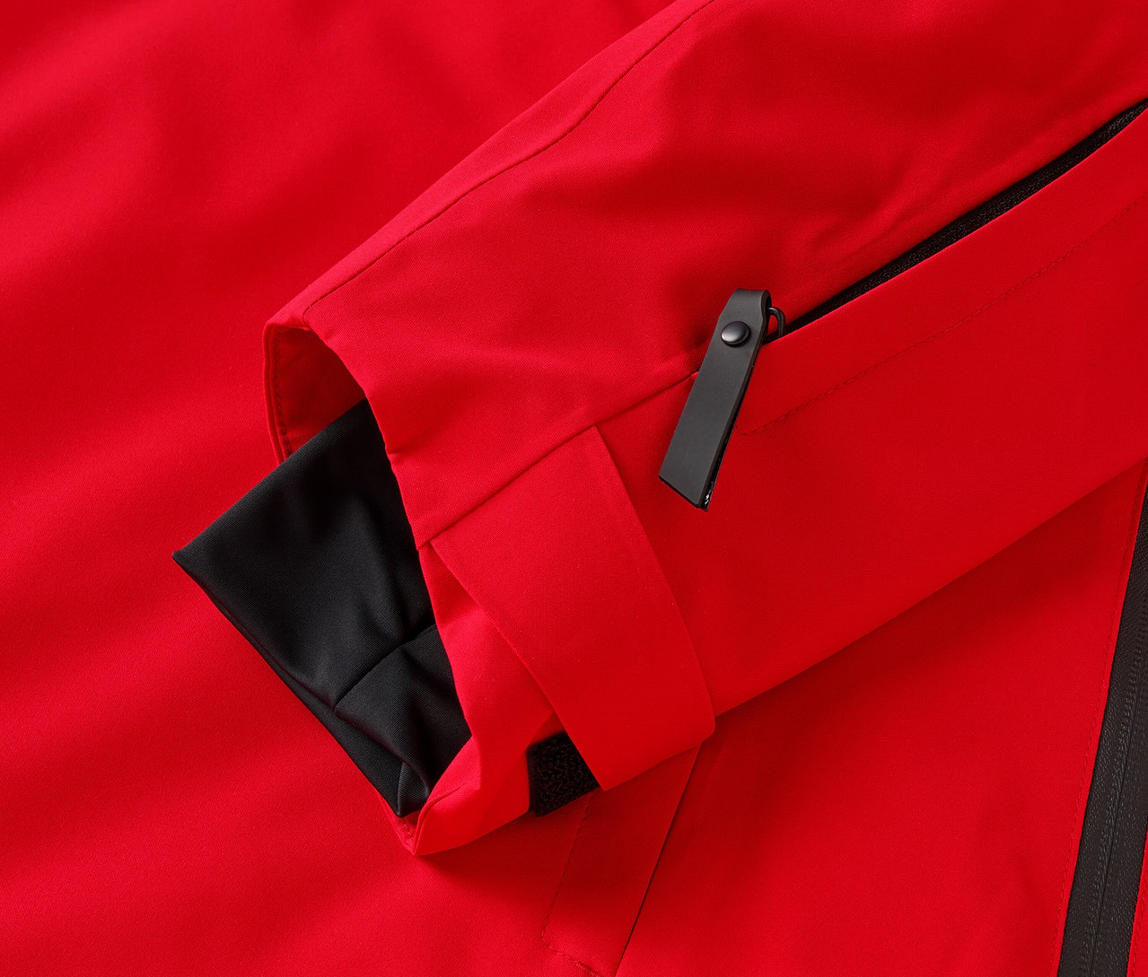 Egy piros kabát részlete fekete elemekkel.