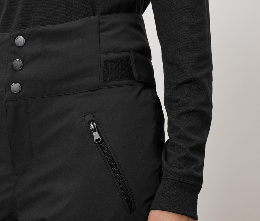 Fekete, magas derekú nadrág három gombbal és cipzáras zsebbel.