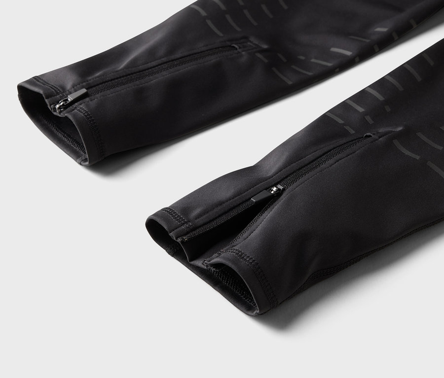 Fekete nadrág részlete cipzárral a szárán.