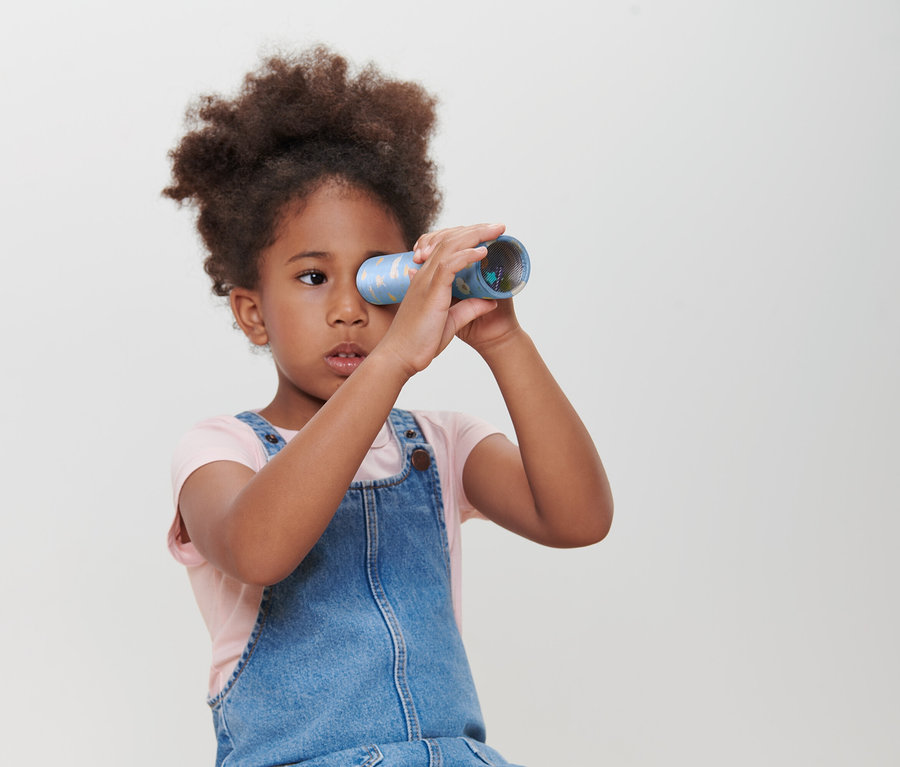 Egy lány egy Kaleidoszkópon néz keresztül.