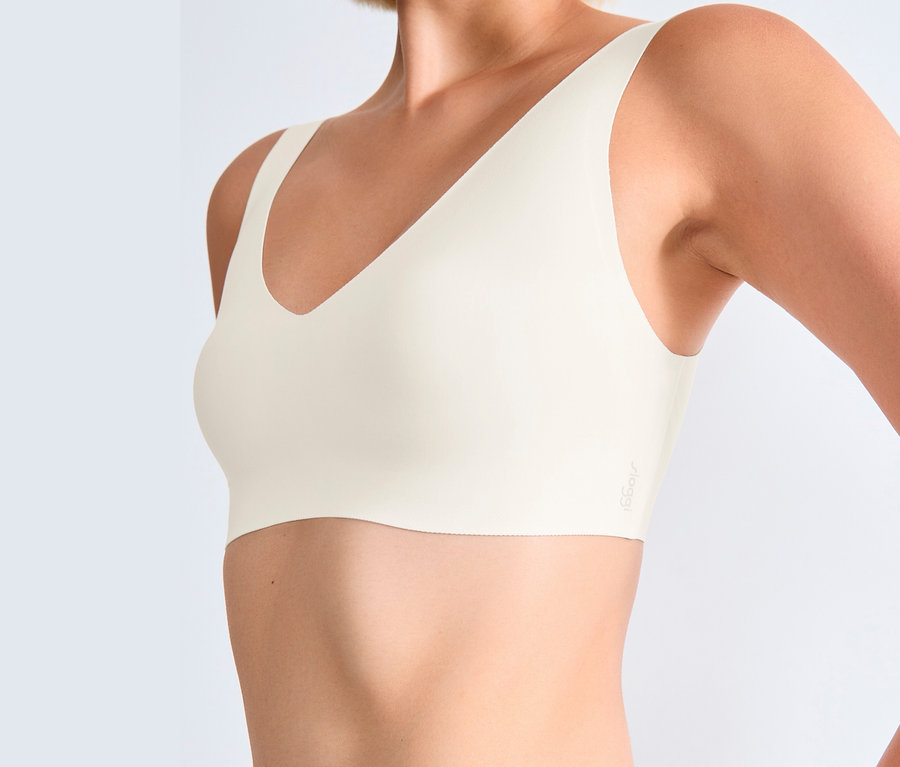 Egy nő törzse selyemfehér sloggi ZERO Feel 2.0 bralette-ben.