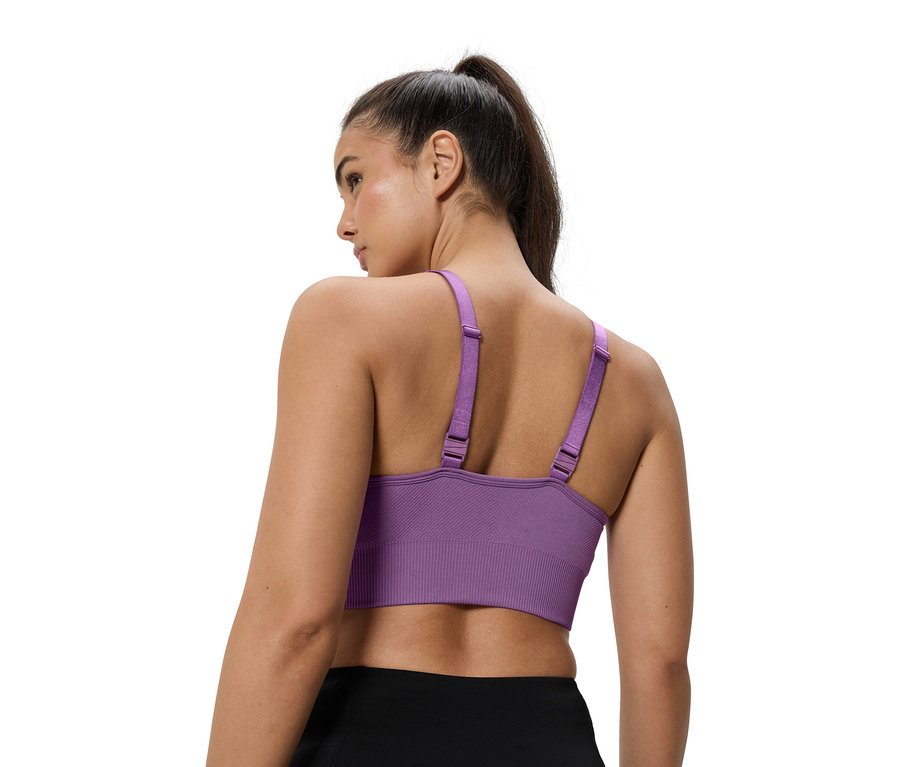 Nő visel egy lila sportmelltartót.