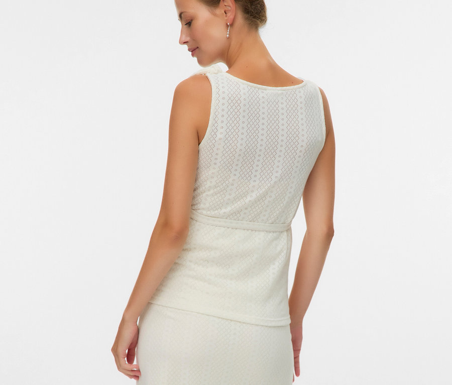 Mögülről egy nő ujjatlan felsőben és mintás szoknyában.