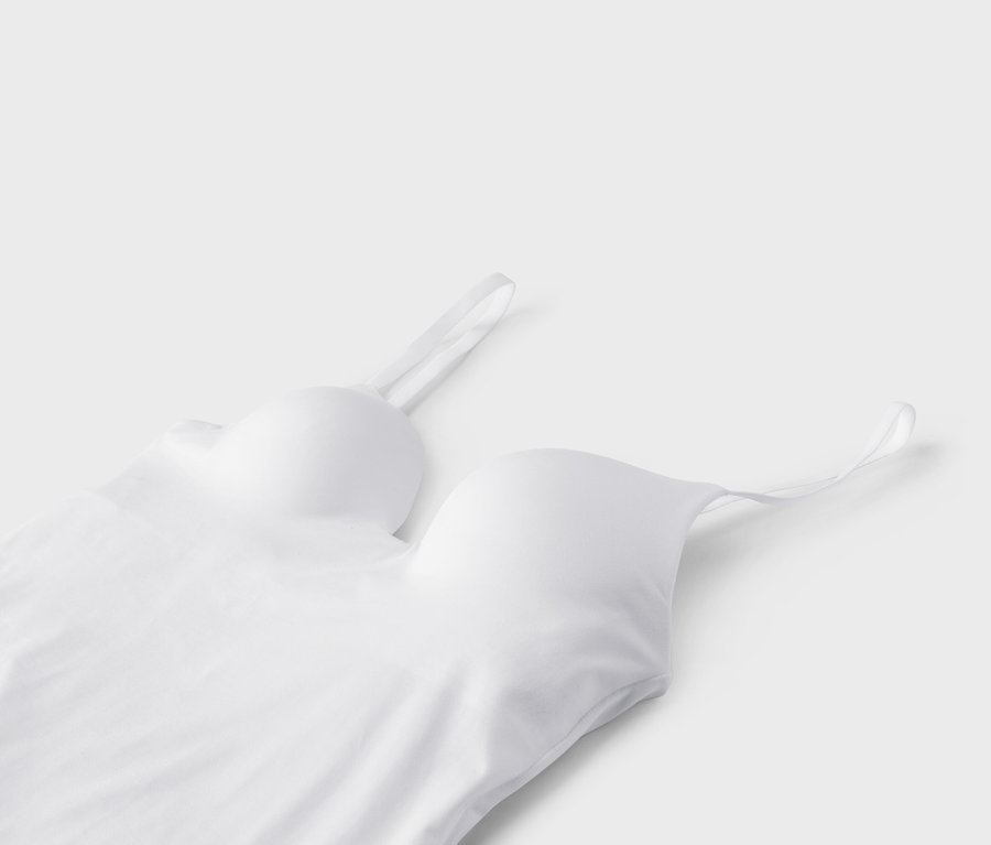 Egy fehér bralette közeli képe vékony pántokkal, fehér háttérrel.