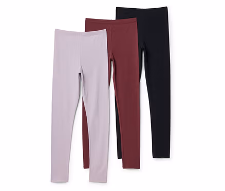 Három leggings lila, bordó és fekete színben egymáson fekszik fehér háttér előtt.