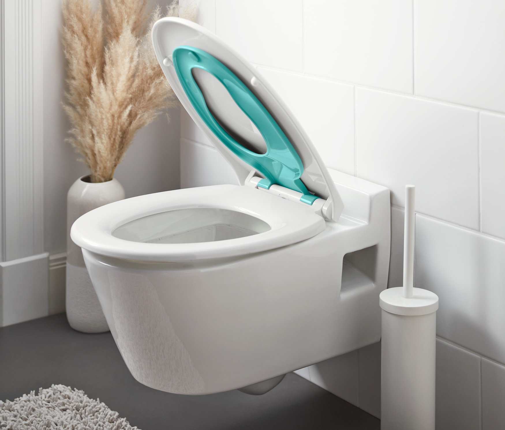 Nyitott »Family« WC-ülőke leeresztő automatikával egy fehér WC-n.