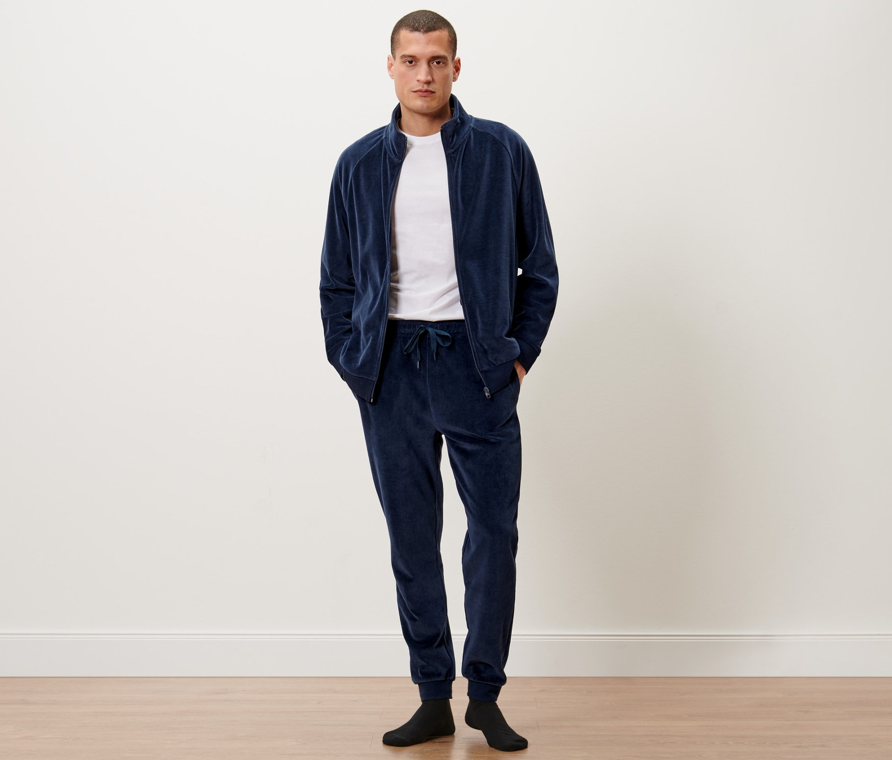 Egy férfi áll plüss szabadidőruhában.