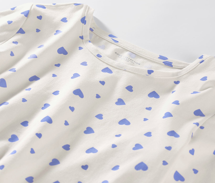 Egy fehér, világoskék szívecskés pizsama részlete.