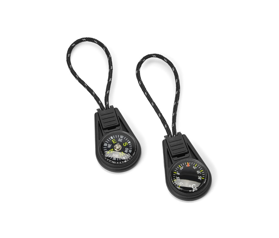 Két cipzárra akasztható hőmérő és iránytű fehér háttérrel.