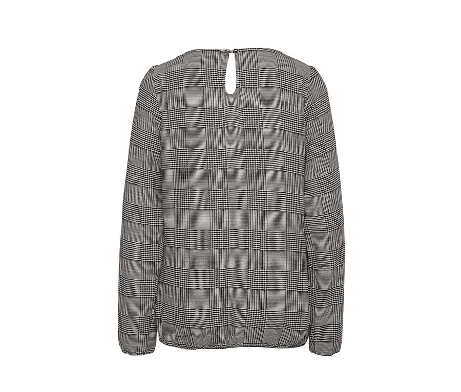 Egy szürke, mintás, női hosszú ujjú blúz részlete.