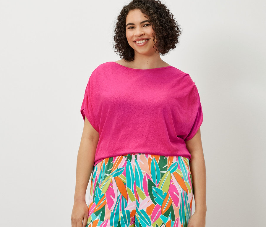 Nő visel nyomott mintás palazzo nadrágot és lentartalmú kevert anyagból készült pólót.