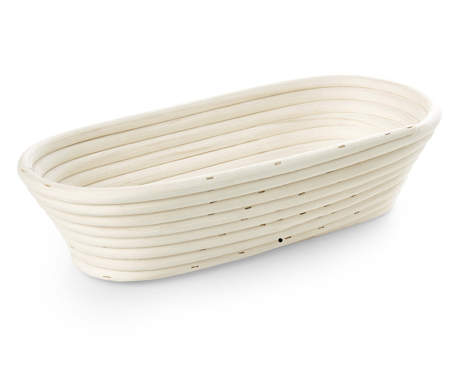 Ovális kenyérkelesztő kosár természetes anyagból, finom vízszintes vonalakkal.