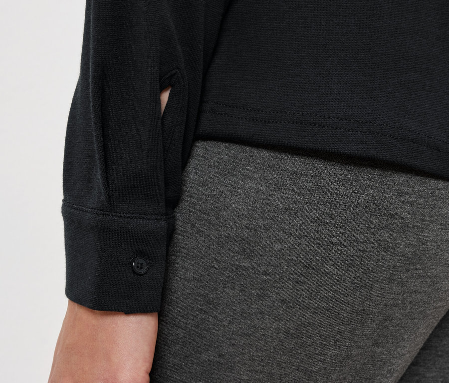 Női szett részlete fekete blúzzal és szürke leggingsszel.